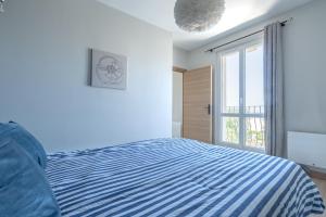 una camera con un letto blu e bianco e una finestra di Le Petit Prince, standing & vue mer a Boulogne-sur-Mer Altre 15 foto