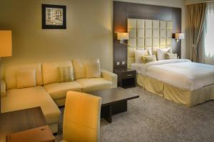een hotelkamer met een bed en een bank bij Golden Ocean Hotel in Doha