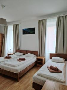 two beds in a hotel room with towels on them at Pension Jahn in Salzburg