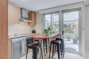 eine Küche mit einem roten Tisch und einigen Hockern in der Unterkunft Blue Ocean Apartment in A Coruña