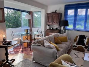 una sala de estar con un sofá y una mesa en LES FERMES DE PINPIN - LE PAVILLON, en Labaroche