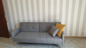 a gray couch with two pillows in a room at sorrento joy in Sorrento