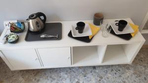 a white cabinet with cups and dishes on it at sorrento joy in Sorrento