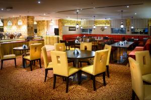 a restaurant with tables and chairs and a bar at Golden Ocean Hotel in Doha