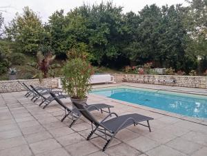a row of chairs next to a swimming pool at La Belle Étape in Montchaude +14 photos