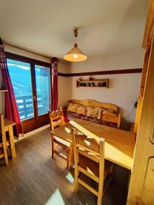ein Wohnzimmer mit Tisch und Couch in der Unterkunft Condo in val thorens by AlpStays in Val Thorens