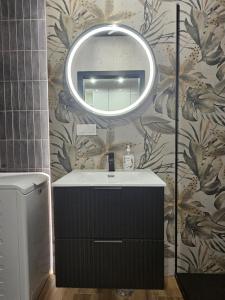 a bathroom with a sink and a mirror on a wall at LOCUS SKY TOWER Katowice in Katowice