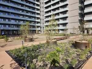 a park with trees and benches in front of a building at LOCUS SKY TOWER Katowice in Katowice