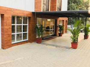 a building with potted plants in front of it at Hotel Golden Plateau in Porvorim