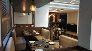 a restaurant with two tables and chairs in a room at Hotel Golden Plateau in Porvorim +1 photo