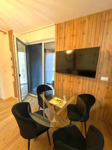 a dining room with a table and chairs and a television at Oaza in Sarajevo