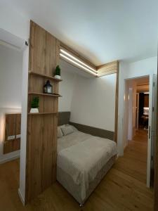 a bedroom with a bed with a wooden wall at Oaza in Sarajevo