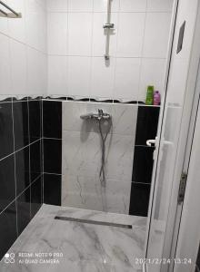bagno con doccia e piastrelle bianche e nere di Adnna Home a Bihać