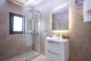 a bathroom with a shower and a sink and a mirror at Orion Luxury Apartments in Nafplio