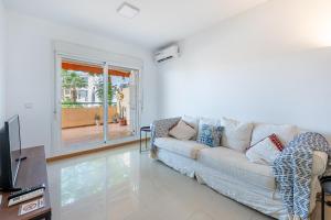 a living room with a couch and a tv at Beautiful 2 Bed Apartment Los Pacos in Las Lagunas Mijas