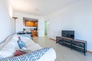 a living room with a white couch and a flat screen tv at Beautiful 2 Bed Apartment Los Pacos in Las Lagunas Mijas
