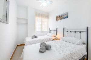 two beds in a room with white walls at Beautiful 2 Bed Apartment Los Pacos in Las Lagunas Mijas +18 photos