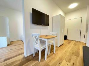 a room with a table and two chairs and a television at AM1094 - Moderne Monteurwohnung Übergangswohnung in Amberg