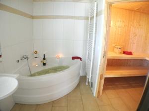a white bathroom with a tub and a sink at Nordic - Nordhorn in Nordhorn