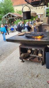 a picnic table with a grill and people standing around at La Grange en Champagne in Hermonville