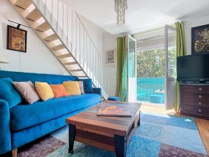 a living room with a blue couch and a table at Duplex Évasion Shanti - à 3 min du Métro in Charenton-le-Pont