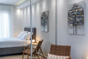 a bedroom with a bed and two chairs at Orion Luxury Apartments in Nafplio +95 photos