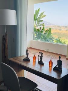 een tafel met drie zwarte beeldjes erop met een raam bij Your dream is real in La Cala de Mijas