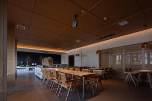 a dining room with wooden tables and chairs at Yanyu Yunxi Resort Hotel 烟雨云兮酒店 in Fenghuang County