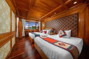 Habitación con 2 camas, paredes de madera y suelo de madera. en Sunlight Boutique Cruise - Cat Ba island, en Ha Long