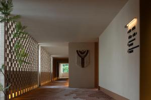 a hallway of a house with a white wall at Yanyu Yunxi Resort Hotel 烟雨云兮酒店 in Fenghuang County