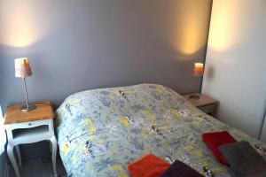 a small bedroom with a bed and two lamps at Appartement calme et lumineux à 5 mn de Paris in Saint-Denis