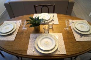 a wooden table with plates and utensils on it at Appartement calme et lumineux à 5 mn de Paris in Saint-Denis