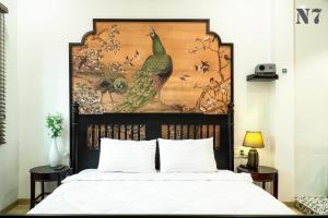 a bedroom with a bed with a painting on the wall at H'homestay quận 1 - N7 in Ho Chi Minh City