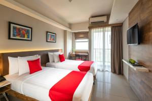 una camera d'albergo con due letti e una televisione di Ramada by Wyndham Serpong a Serpong