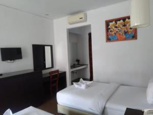 Ένα ή περισσότερα κρεβάτια σε δωμάτιο στο Hotel Ompu Herti