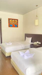 Ένα ή περισσότερα κρεβάτια σε δωμάτιο στο Hotel Ompu Herti