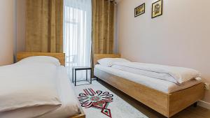 a bedroom with two beds and a window at VacationClub Apartamenty Zakopiańskie Apart 314 in Zakopane