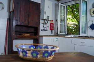 a bowl on a table in a kitchen with a window at Casa do Limoeiro 1 in Valezim