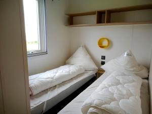 two beds in a room with a window at Regenbogen Tossens in Butjadingen