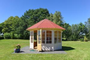 a gazebo with a red roof in a yard at Ferienwohnung im Landhaus Eulennest in Stedesdorf
