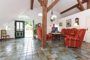 a living room with red chairs and a table at Ferienwohnung im Landhaus Eulennest in Stedesdorf