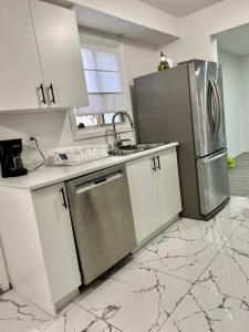 a kitchen with white cabinets and a stainless steel refrigerator at Private Room Near Airport K8 in Mississauga