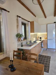 a kitchen with a table and a sink and a refrigerator at Wind Apartment in Agia Roumeli in Agia Roumeli +15 photos