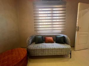a couch sitting in a room with a window at Rawdat Zayed Compound in Sheikh Zayed