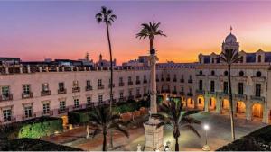 duży biały budynek z palmami przed nim w obiekcie Piso Museo del Realismo-Catedral-Alcazaba-Free Parking-Wifi-Aire acondicionado w mieście Almería