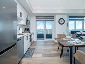 a kitchen and living room with a table and a dining room at City View 1BR Condo - King Bed & Private Balcony in Kitchener