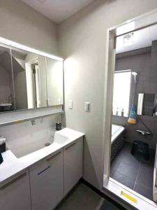 een badkamer met een wastafel en een grote spiegel bij 洗足21 in Tokyo +37 foto's