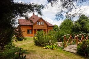 a wooden house with a wooden bridge in a yard at Żurobianka in Żurobice