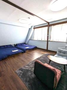 een kamer met bedden, een tafel en een stoel bij 洗足21 in Tokyo