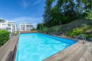 a swimming pool on a wooden deck next to a building at Villa Paula - WG03 strandnah mit Kamin, Terrasse, Balkon in Ostseebad Sellin